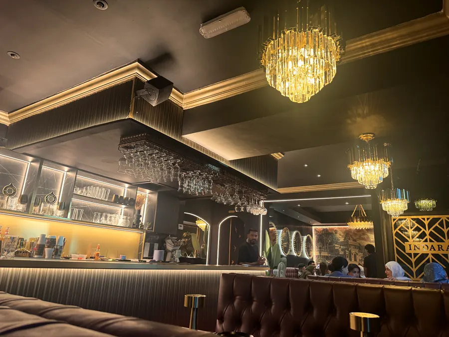 The bar under crystal chandeliers, with gold chevron screens