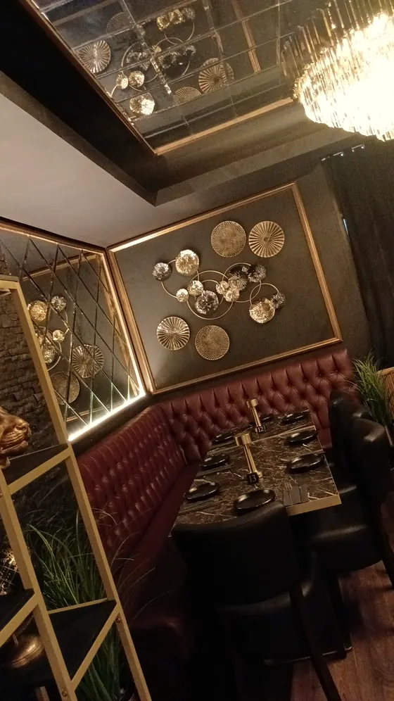 A corner booth with gold plates on the wall